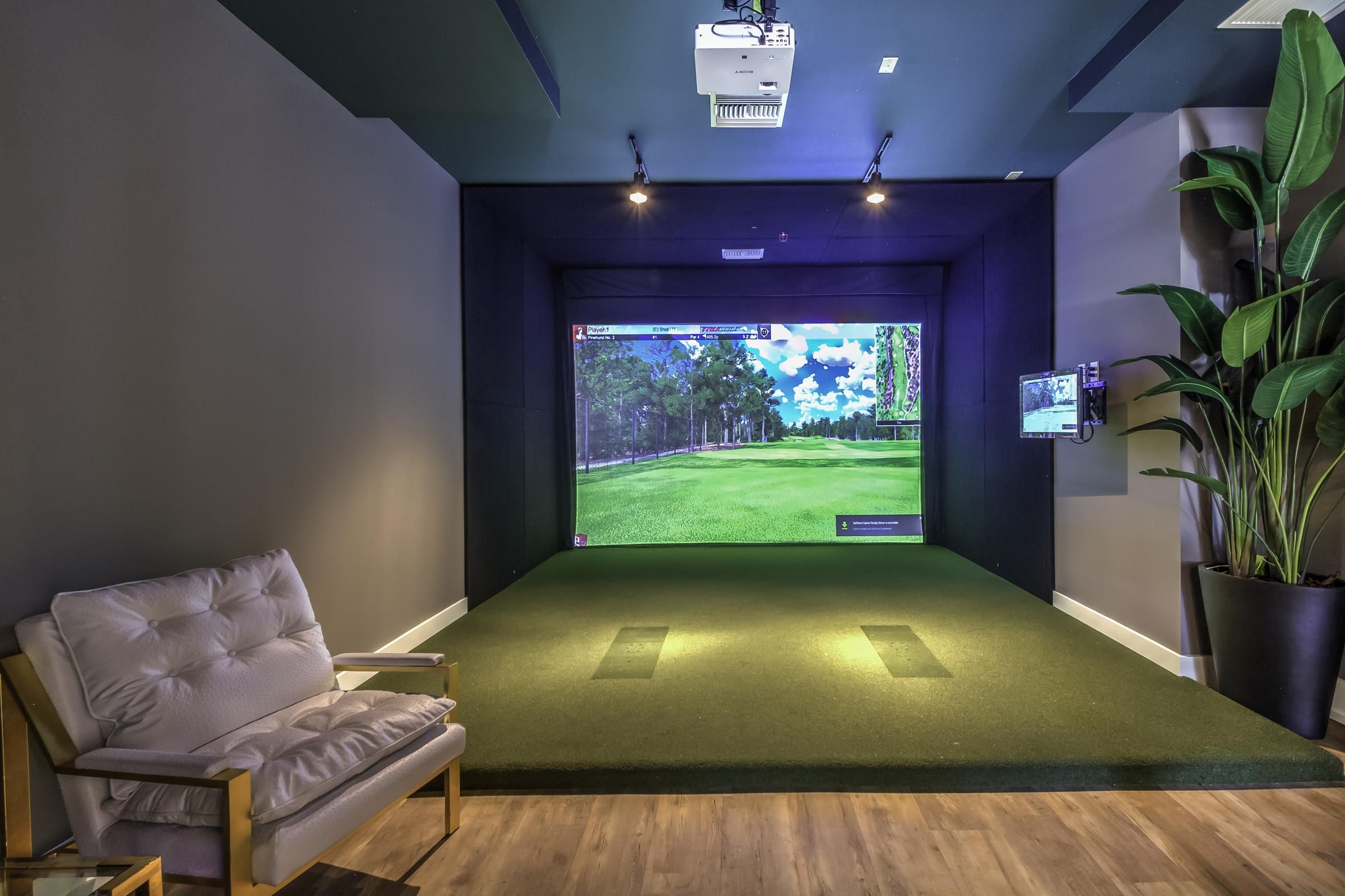 Solstice Apartments virtual golf resident amenity with large screen and private room.