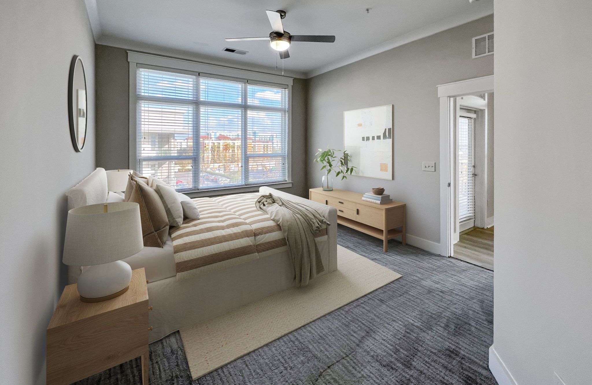 Solstice apartments spacious bedroom with carpeting and large windows furnished with a bed and end tables