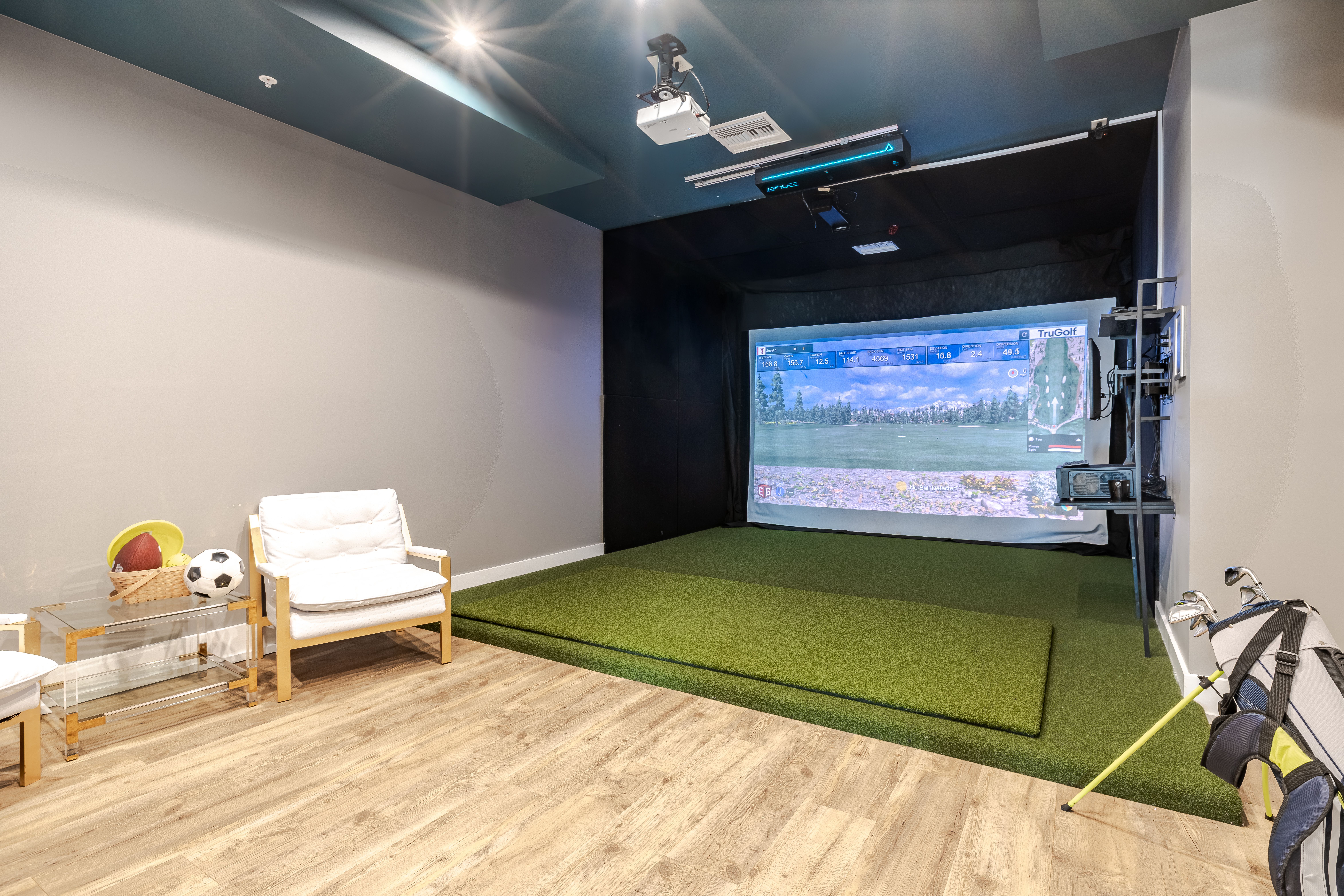 Solstice Apartments virtual golf resident amenity with large screen and private room.