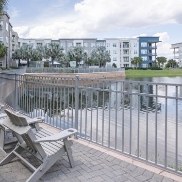 Solstice Apartments property exterior featuring lounge chairs alongside extensive waterway with lush landscaping