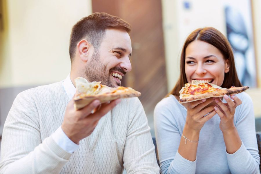 Couple eating pizza together outside theme park in Orlando Florida