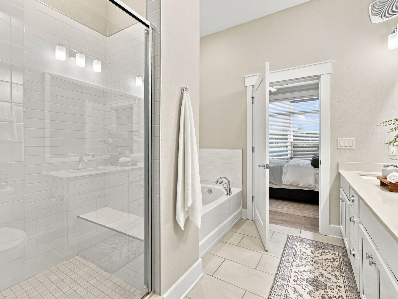 Elegant bathroom at Solstice Apartments equipped with dual sinks, large mirror, and a connected walk-in closet with organized storage.